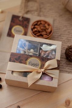 a gift box with nuts and chocolates in it sitting on a table next to some coffee beans