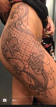 a woman's thigh with an intricate tattoo on it