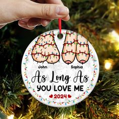 a hand holding a christmas ornament that says, as long as you love me