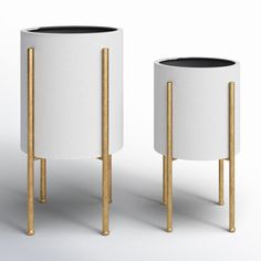 two white and gold planters sitting next to each other