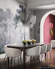 a dining room table with chairs around it and a wallpapered background on the wall