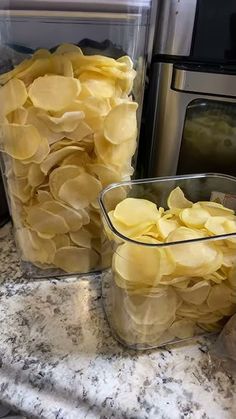 two plastic containers filled with potatoes sitting on top of a counter next to an oven