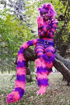 a woman in purple and pink costume sitting on a tree branch