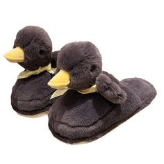 two slippers with bows on them are made to look like ducks, one is brown and the other is black