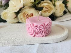 a small pink candle sitting on top of a white plate