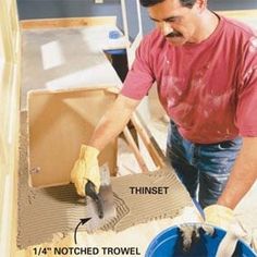 a man is sanding the floor in front of an unfinished piece of furniture that has been placed on top of it