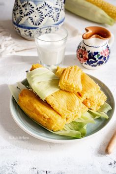 corn on the cob and milk are sitting on a plate next to other dishes