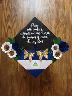 a graduation cap decorated with blue flowers and writing on it that says, pora mis paques ques enfomendos de buertos y cuees