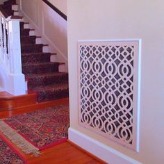 a stair case next to a set of stairs with a rug on the floor below it