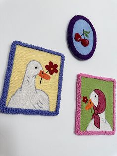 three embroidered patches with birds and flowers on them