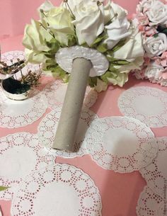 a table with white flowers and doily on it