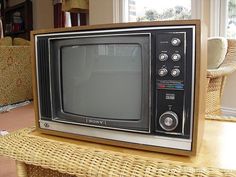 an old tv sitting on top of a wicker table