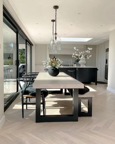 a dining room table with chairs and vases on it