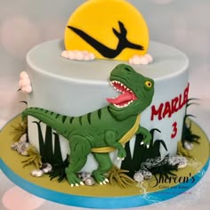 a birthday cake with a dinosaur on top