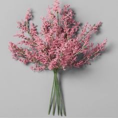 a bunch of pink flowers sitting on top of a gray wall next to each other