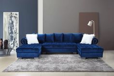 a living room with blue couches and rugs on the floor in front of a gray wall