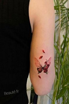 a woman's arm with a butterfly tattoo on the left side of her arm