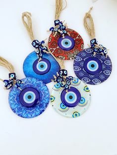 four evil eye glass ornaments hanging from twine