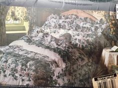 an advertisement for a bed in a bedroom with floral bedspread and curtains on the window sill