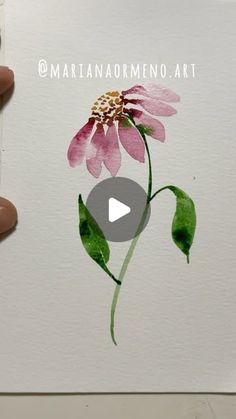 someone is painting a flower with watercolors on paper