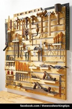 a wall mounted tool rack filled with lots of tools