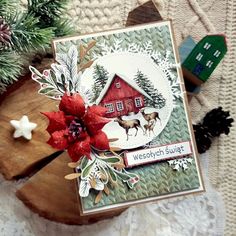 a close up of a christmas card on a table with pine cones and snowflakes