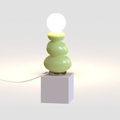 a green lamp sitting on top of a white block