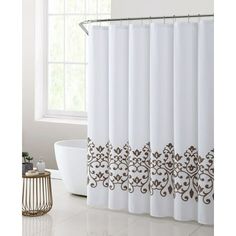 a white shower curtain with brown designs on the bottom and side, in front of a bathtub