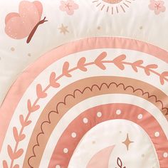 a pink and white bed spread with an image of a moon, stars, and clouds on it