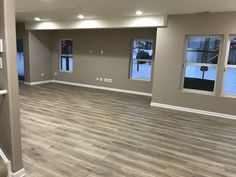 an empty room with wood floors and windows