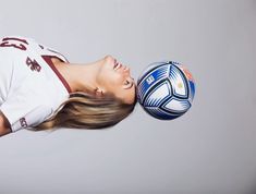 a young woman is playing with a soccer ball