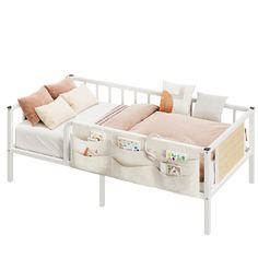 a white bed with two pillows on top of it and an infant crib next to it