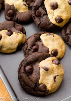 chocolate chip cookies with googly eyes are on a baking sheet, ready to be eaten