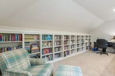 a living room filled with lots of furniture and bookshelves next to a window