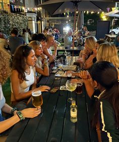 a group of women sitting at a table drinking beer