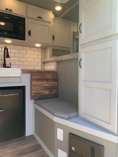 a kitchen with white cabinets and wood flooring