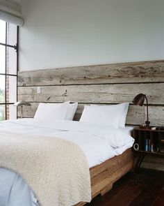 a bed with white sheets and pillows in a bedroom