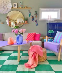 the living room is decorated in pastel colors and has a checkered rug on the floor