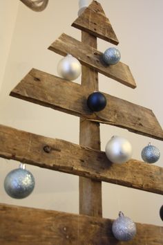 a wooden christmas tree with ornaments hanging from it