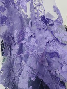 purple flowers and butterflies are on the sheer fabric, which is attached to a vase