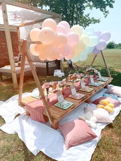 a picnic table with balloons and desserts on it