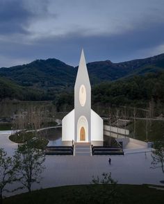 a large church with a steeple in the middle of it's courtyard at night