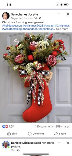 a christmas stocking hanging on the front door with flowers and greenery in it