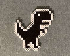 a black and white pixelated dinosaur sitting on top of a gray surface