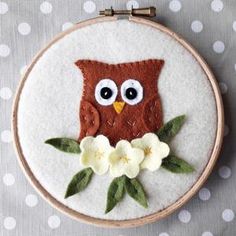 an embroidered owl sitting on top of a white flower