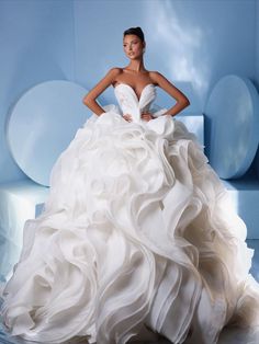 a woman in a white wedding dress standing on a blue chair with her hands on her hips