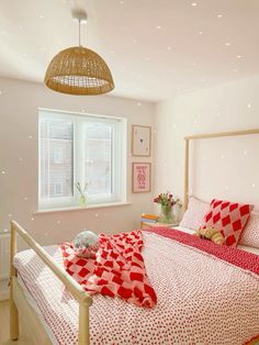 a bed room with a neatly made bed and a basket hanging from the ceiling above it