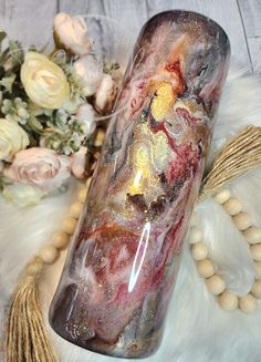 a glass vase sitting on top of a white fur covered floor next to some flowers