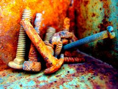 an old rusted metal object with screws and nails