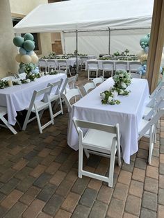 tables and chairs are set up for an outdoor event with white tablecloths on them